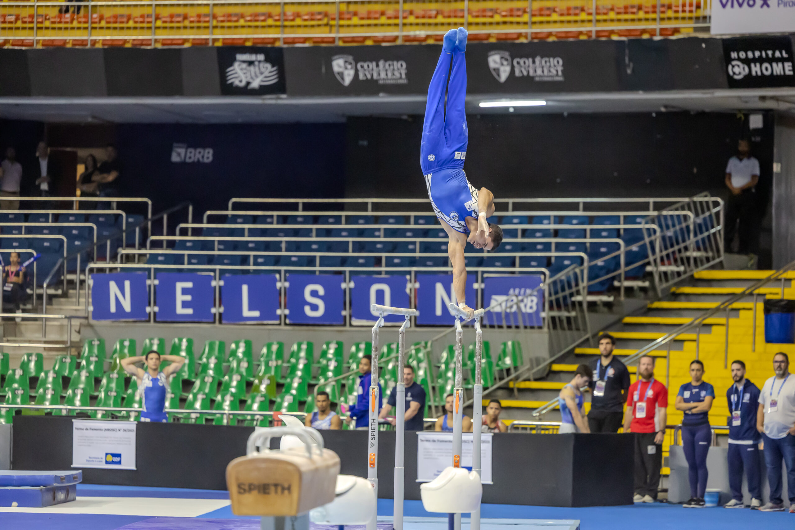 Ginasta invertida acima da trave em competi&ccedil;&atilde;o do Trof&eacute;u Brasil de Gin&aacute;stica