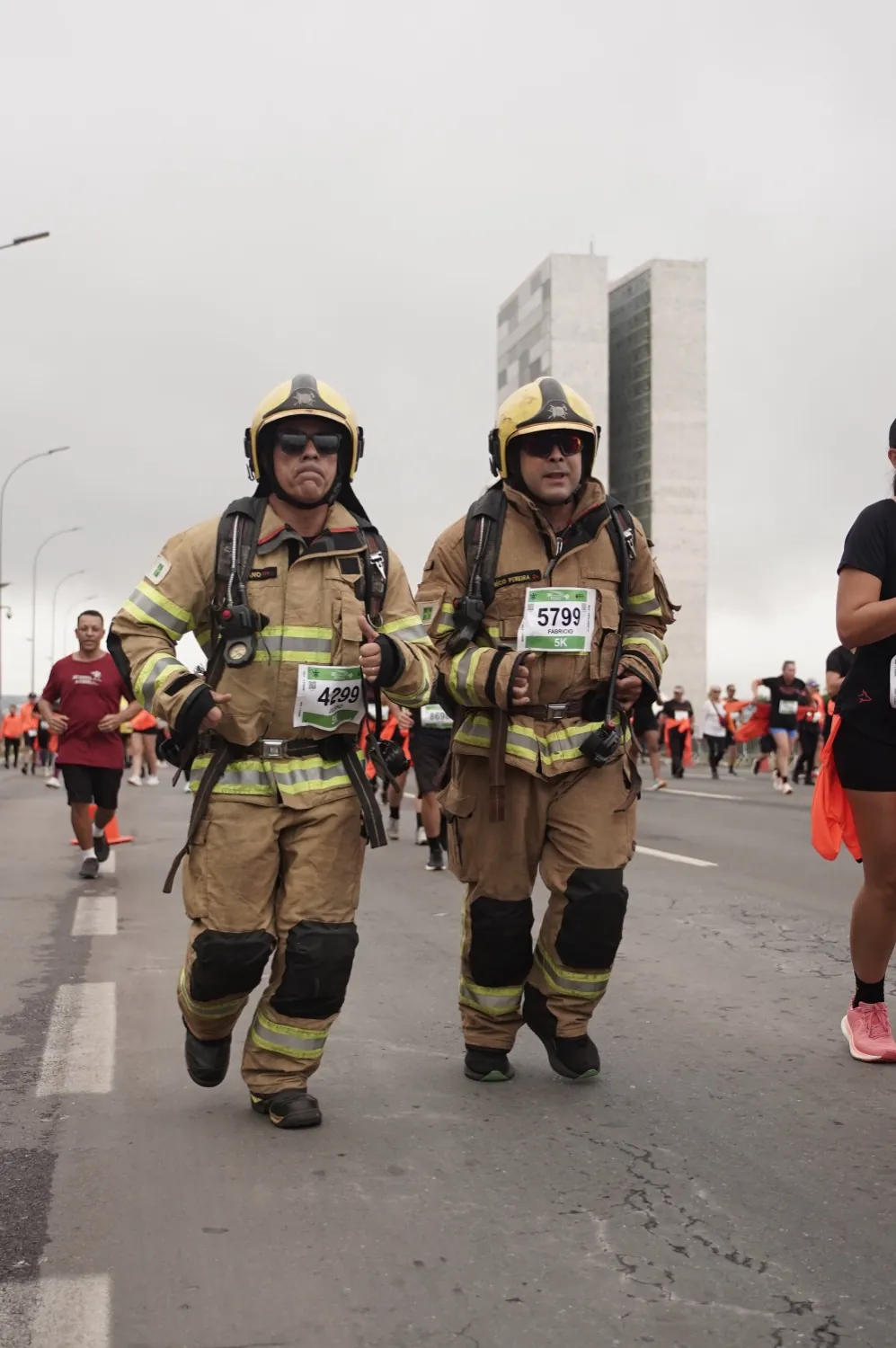 Bombeiros correndo em traje de opera&ccedil;&atilde;o com o Congresso ao fundo