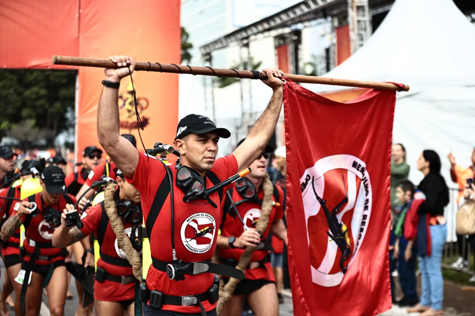 Bombeiro erguendo viga com a bandeira do Mergulho de Resgate