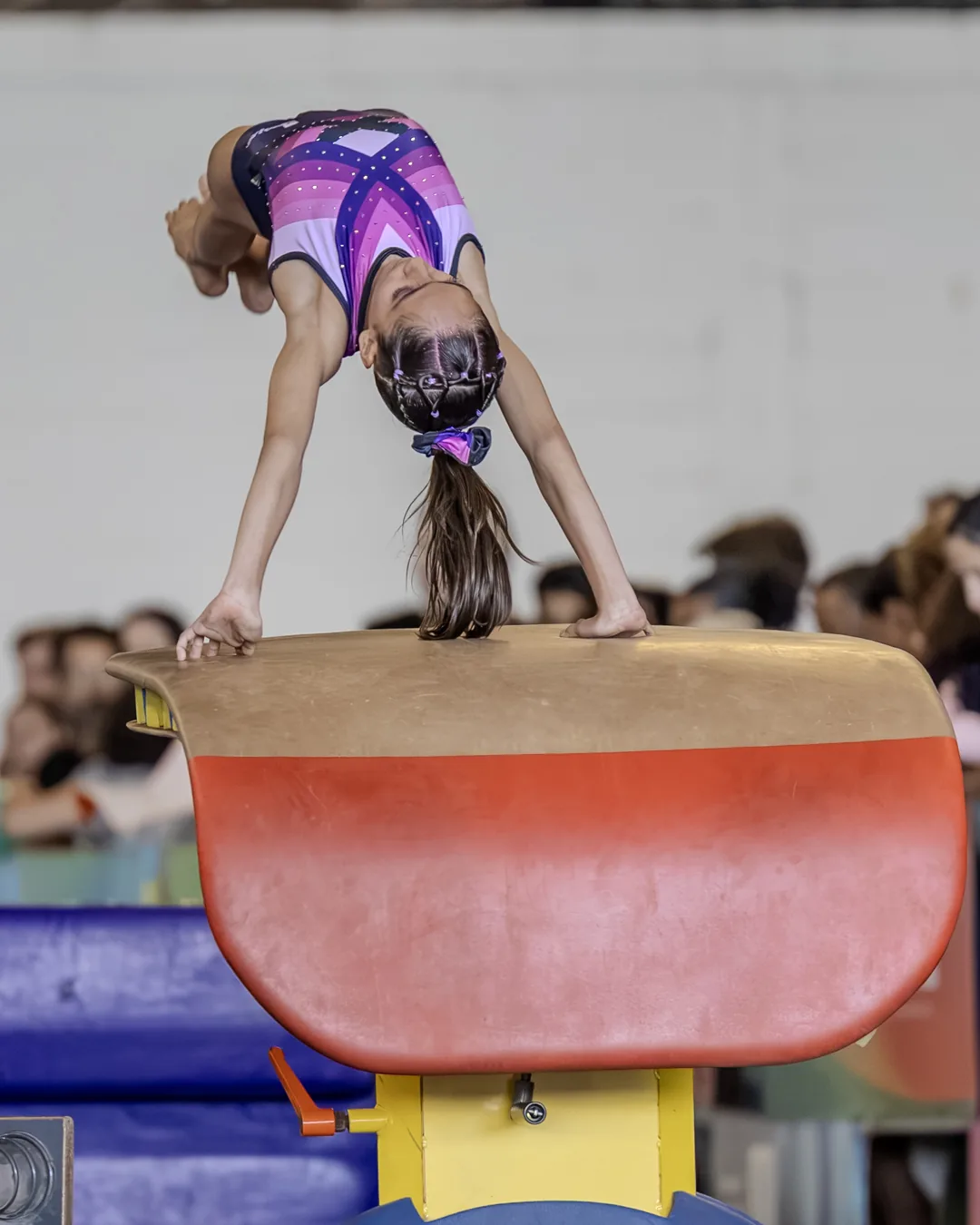 Ginasta apoiada na mesa de salto durante a impulsão