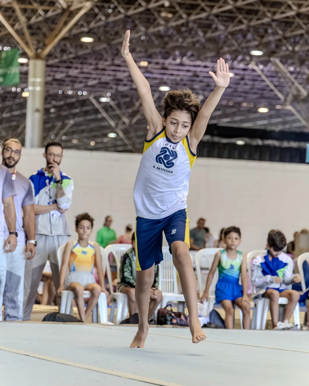 Ginasta finalizando a série de solo com os braços ao alto