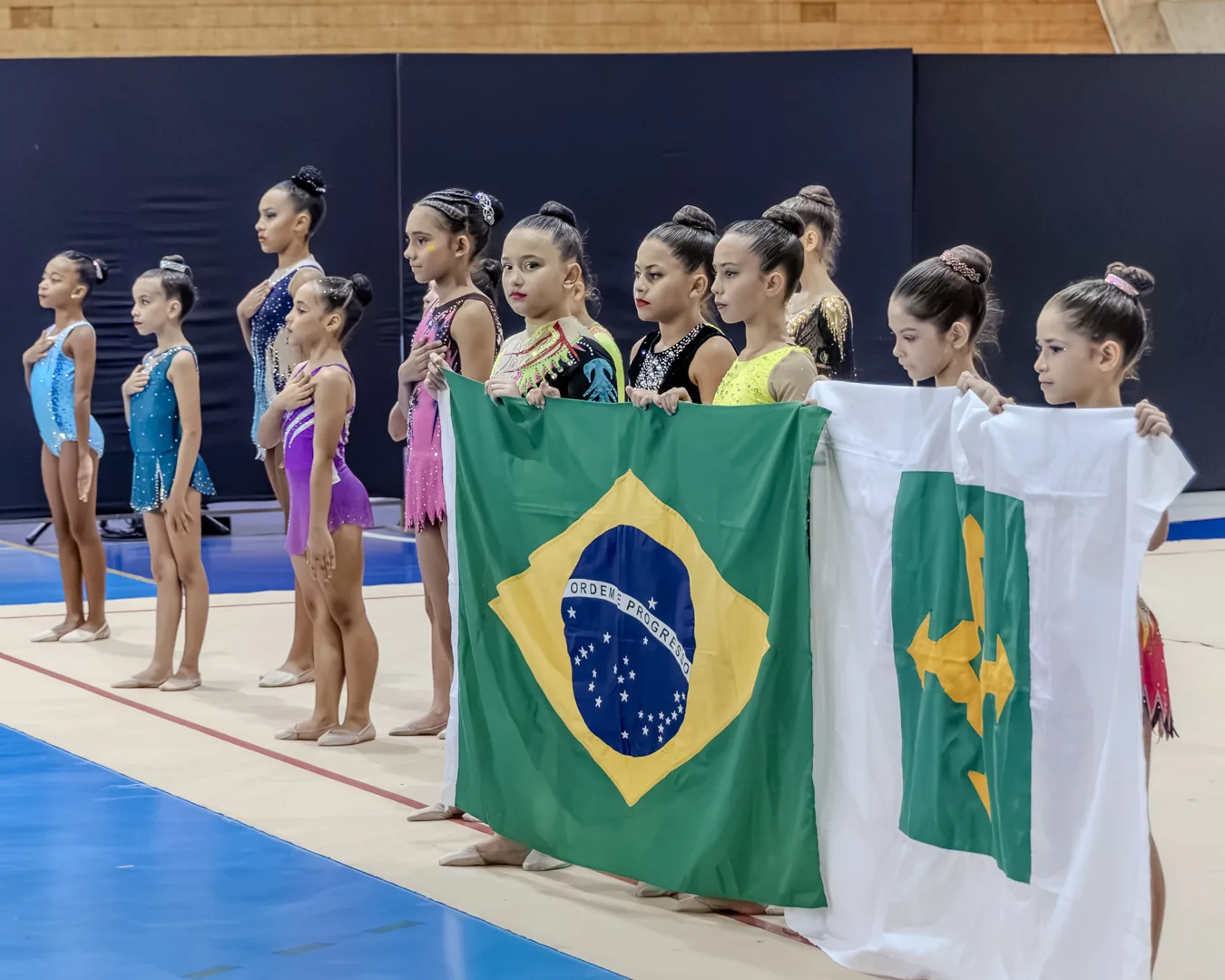 Ginastas perfiladas com as bandeiras do Brasil e do DF na abertura
